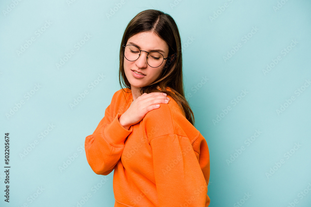 Young caucasian woman isolated on blue background having a shoulder pain. Young caucasian woman isolated on blue background having a shoulder pain.