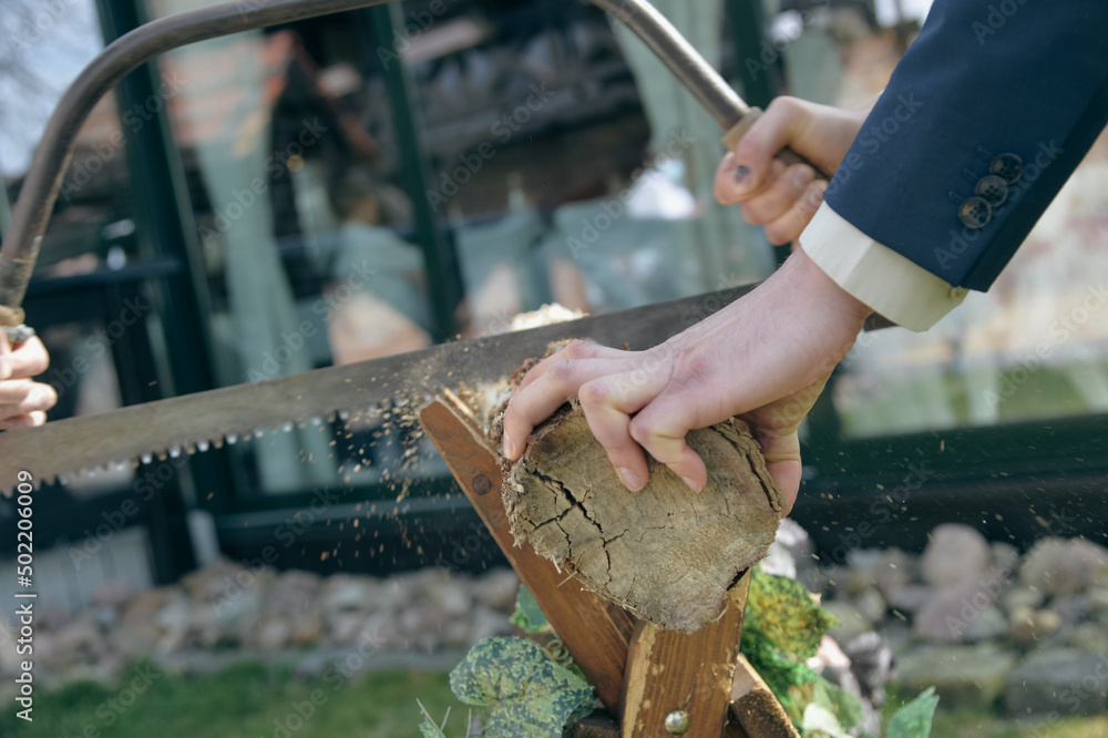 hand beim baumstammsägen brautpaar baum säge braut bräutigam ehe
