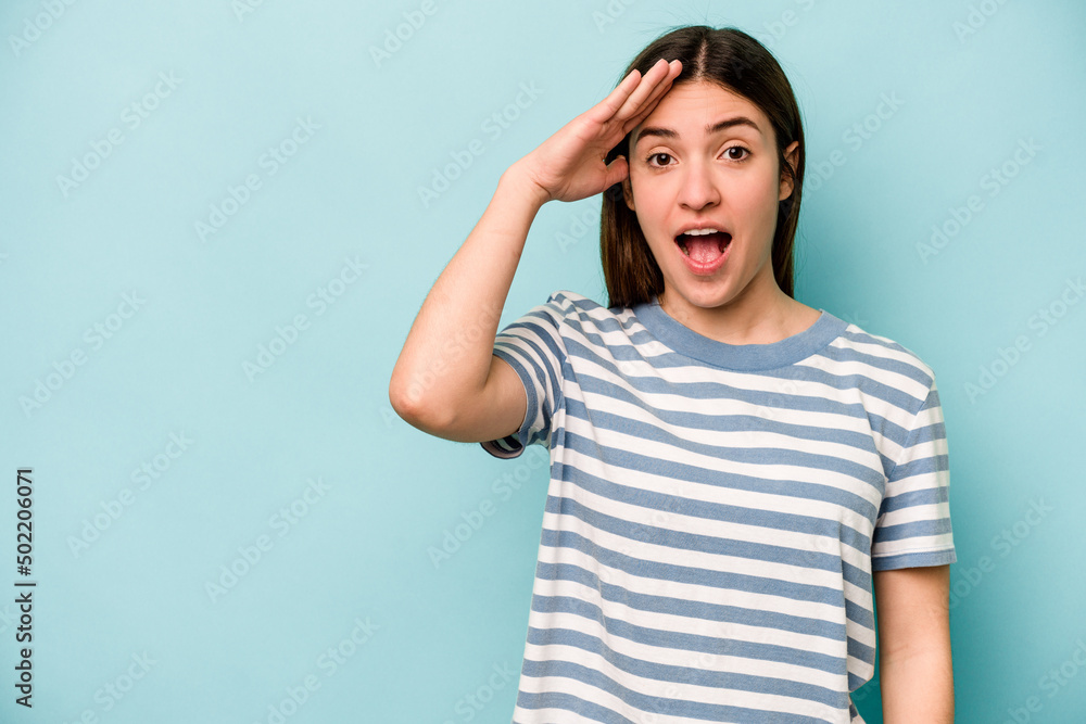 Young caucasian woman isolated on blue background shouts loud, keeps eyes opened and hands tense. Young caucasian woman isolated on blue background shouts loud, keeps eyes opened and hands tense.
