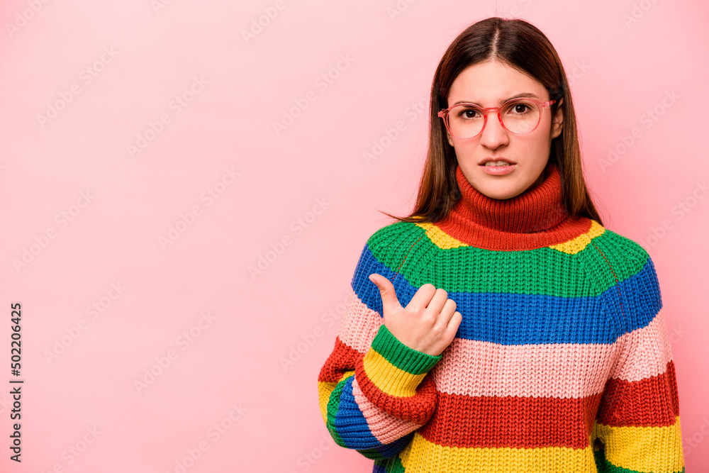 Young caucasian woman isolated on pink background shocked pointing with index fingers to a copy space. Young caucasian woman isolated on pink background shocked pointing with index fingers to a copy space.