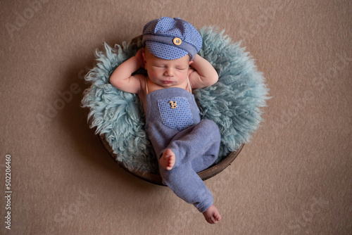 beautiful newborn baby sleeps in a blue cute suit