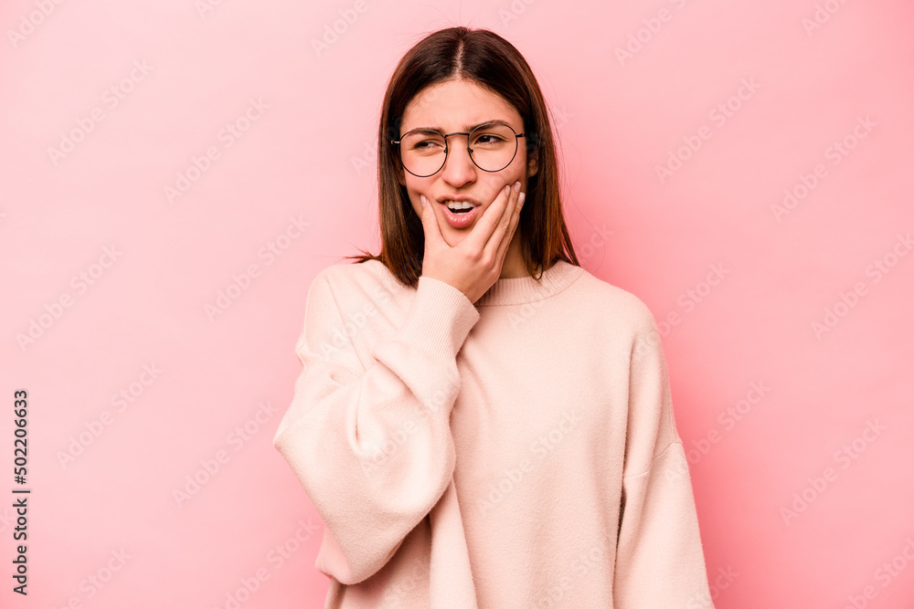 Young caucasian woman isolated on pink background having a strong teeth pain, molar ache.