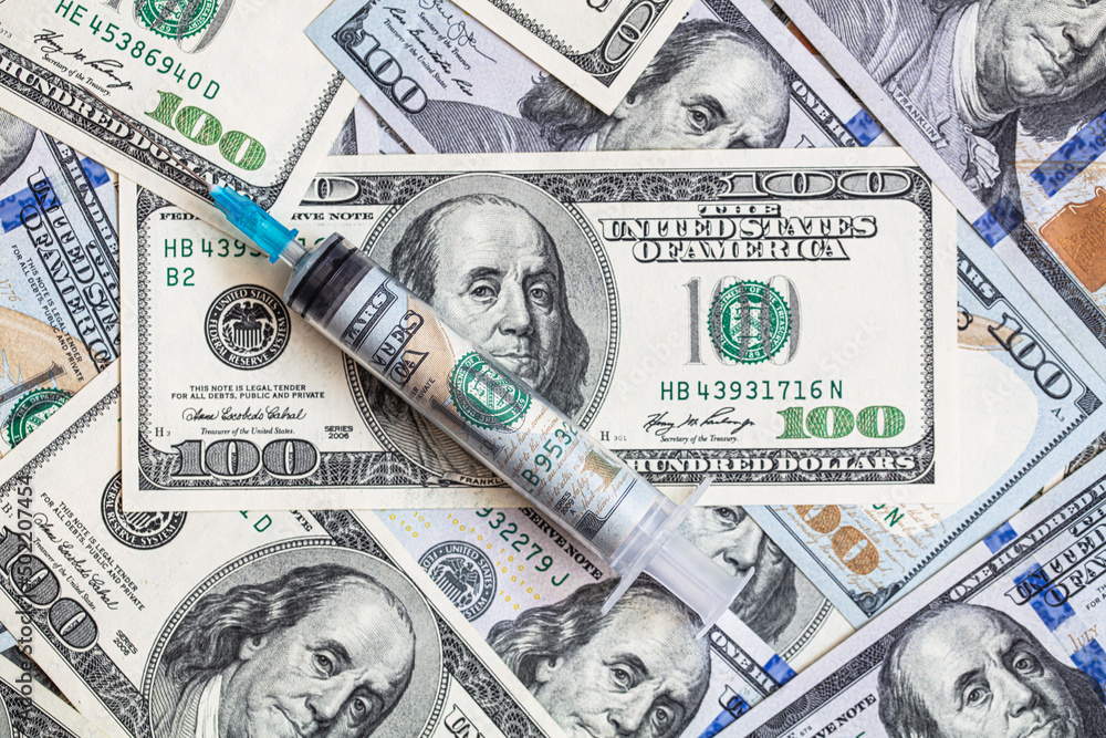 Fototapeta premium Syringe with 100 dollar banknote inside