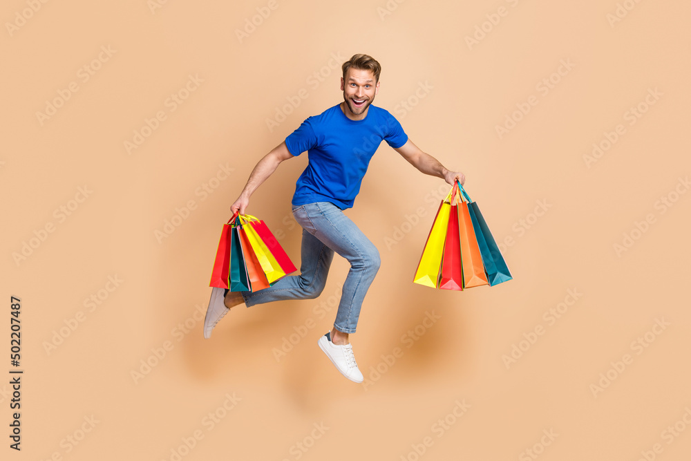 Full size profile side photo of young cheerful man energetic rush speed store discount isolated over beige color background Full size profile side photo of young cheerful man energetic rush speed store discount isolated over beige color background
