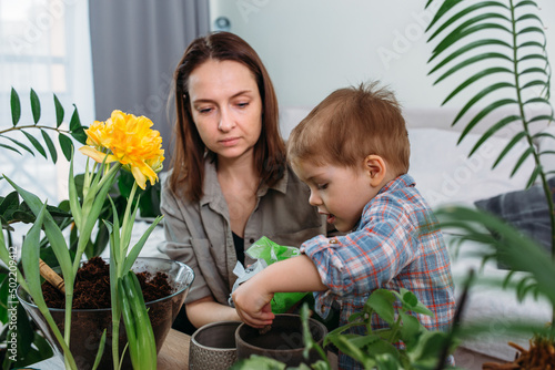 Mom and little son are transplanting houseplants together
