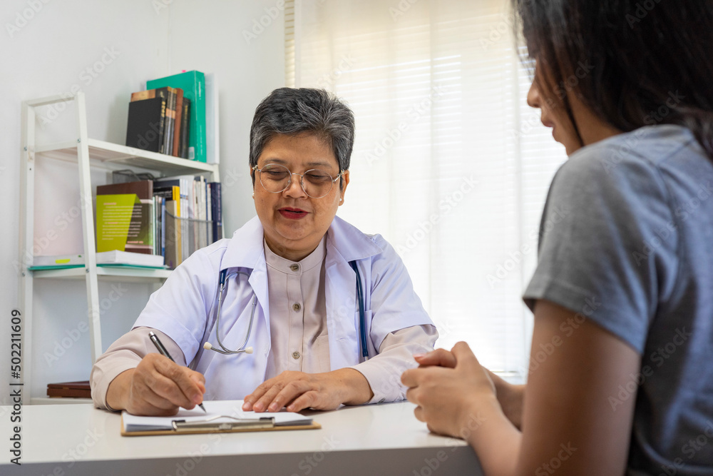 General practitioner taking notes when talking to female patient in hospital. General practitioner taking notes when talking to female patient in hospital.