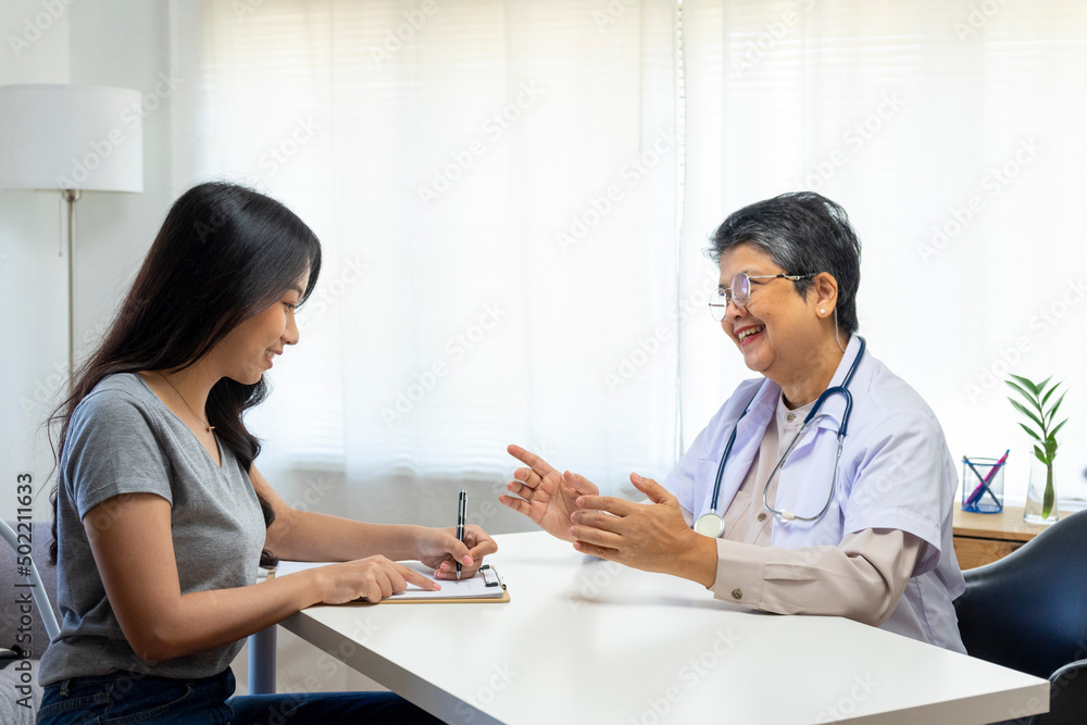 General practitioner taking notes when talking to female patient in hospital. General practitioner taking notes when talking to female patient in hospital.