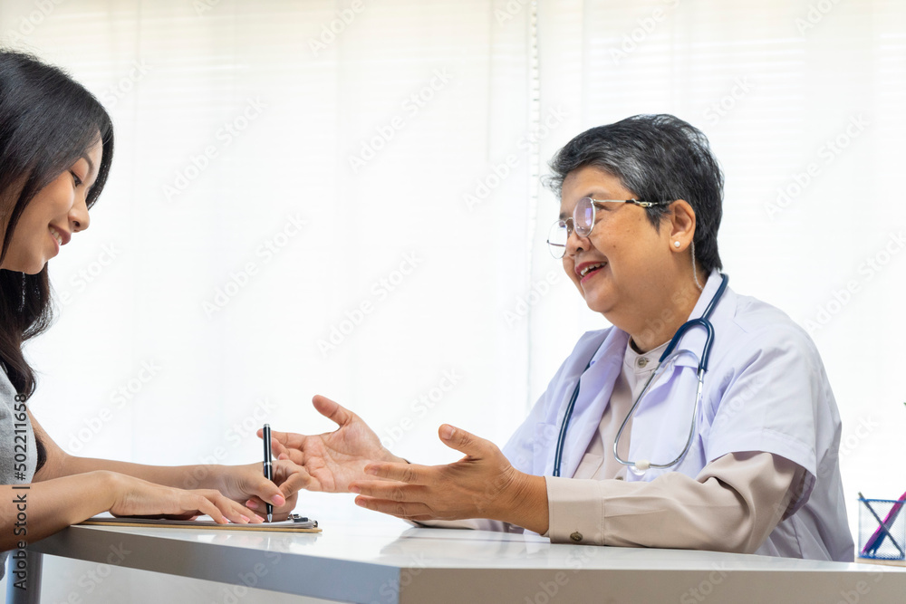 General practitioner taking notes when talking to female patient in hospital. General practitioner taking notes when talking to female patient in hospital.