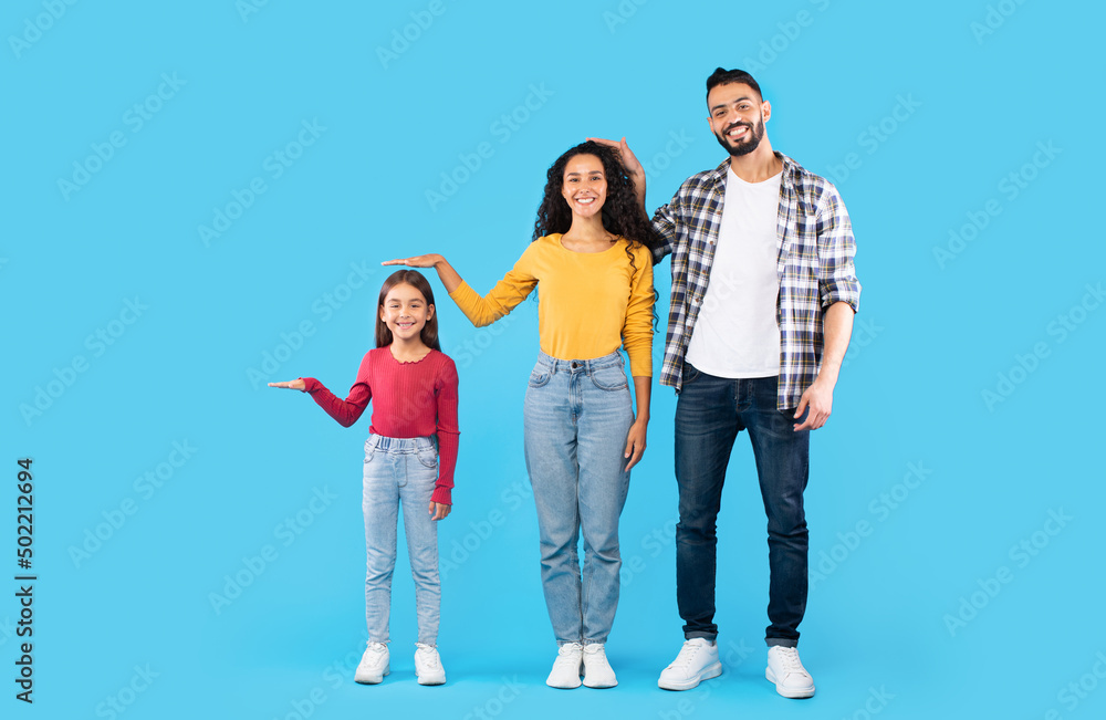Middle Eastern Family Showing Each Other's Height, Blue Background