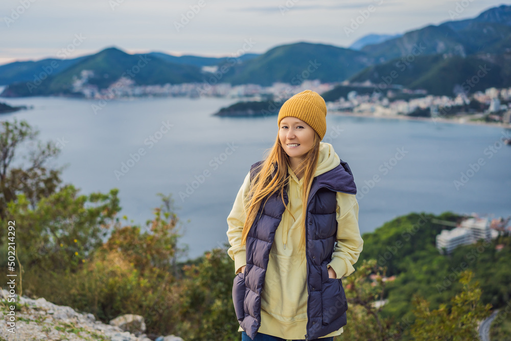 Woman in the mountains of Montenegro in warm clothes. Travel to Montenegro in spring, autumn, winter