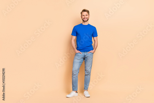 Full size photo of young cheerful man smart arms in pocket wear modern outfit isolated over beige color background