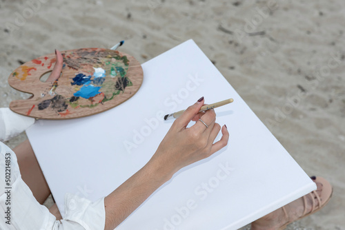 woman drawing with painting tools, oil color and wooden paint palette. photo