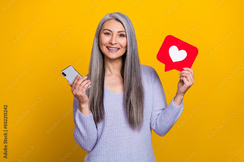 Photo of attractive modern grandma receive many likes on her blog post isolated on yellow color background Photo of attractive modern grandma receive many likes on her blog post isolated on yellow color background