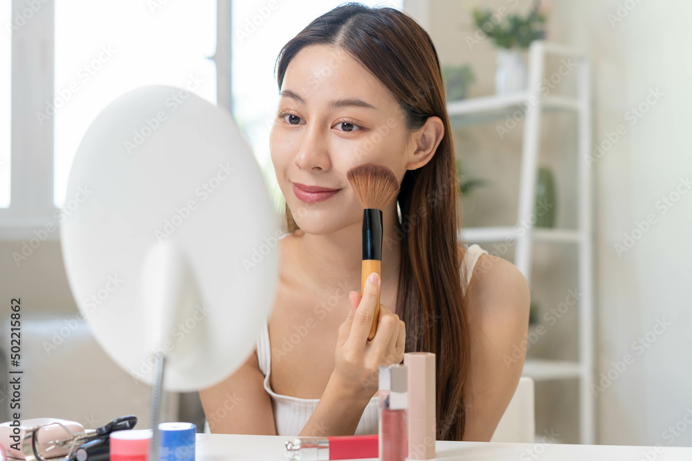 Happy beauty blogger concept, cute asian young woman, girl smile, make up face by applying brush blush powder on her cheek, looking at the mirror. People look with natural fashion style. Happy beauty blogger concept, cute asian young woman, girl smile, make up face by applying brush blush powder on her cheek, looking at the mirror. People look with natural fashion style.