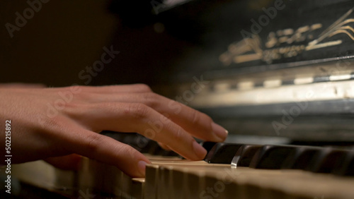 A young woman playing piano closeup. Piano hands pianist playing Musical instruments details with player hand closeup