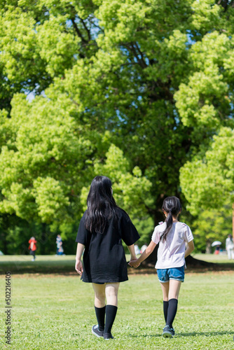 初夏の公園で元気で遊んでいる子供姉妹の姿