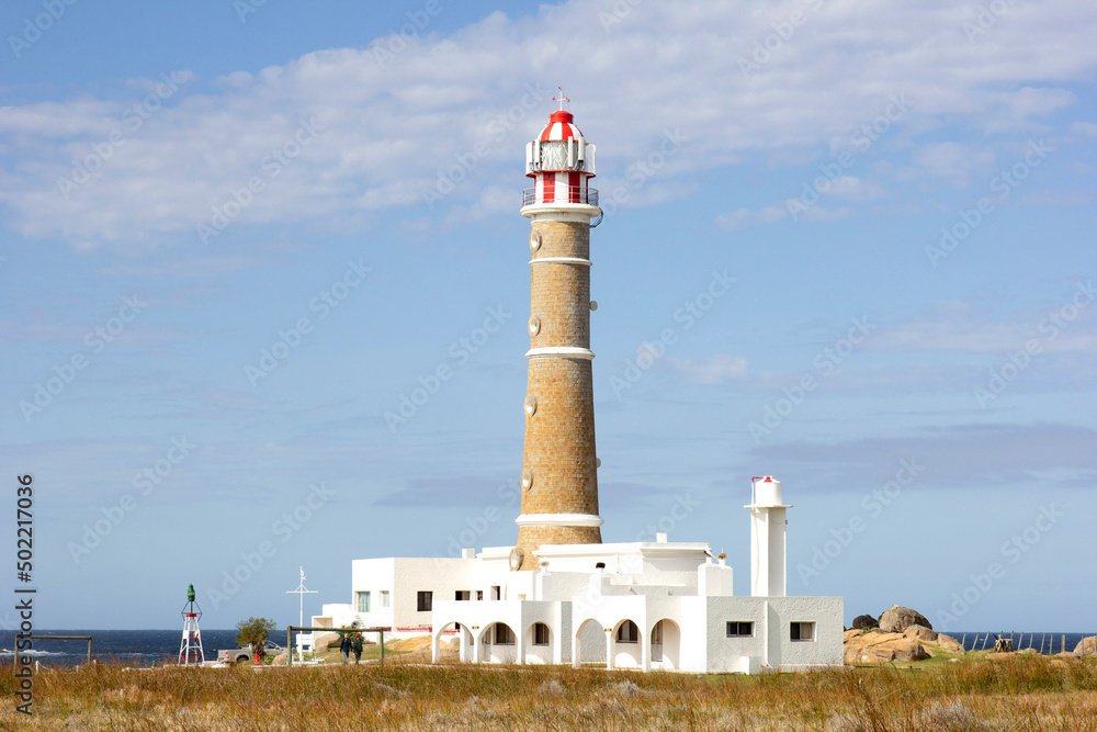 Landscape of Cabo Polonio, Uruguay. It is possible to see the fort and the lighthouse, the soil and the rocks. The building in red and white, is on the sea coast. Landmark, tourist point.