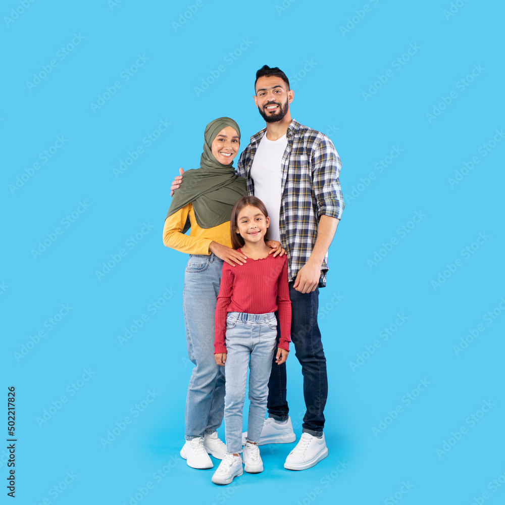 Happy Muslim Family Embracing Posing Smiling Standing Over Blue Background