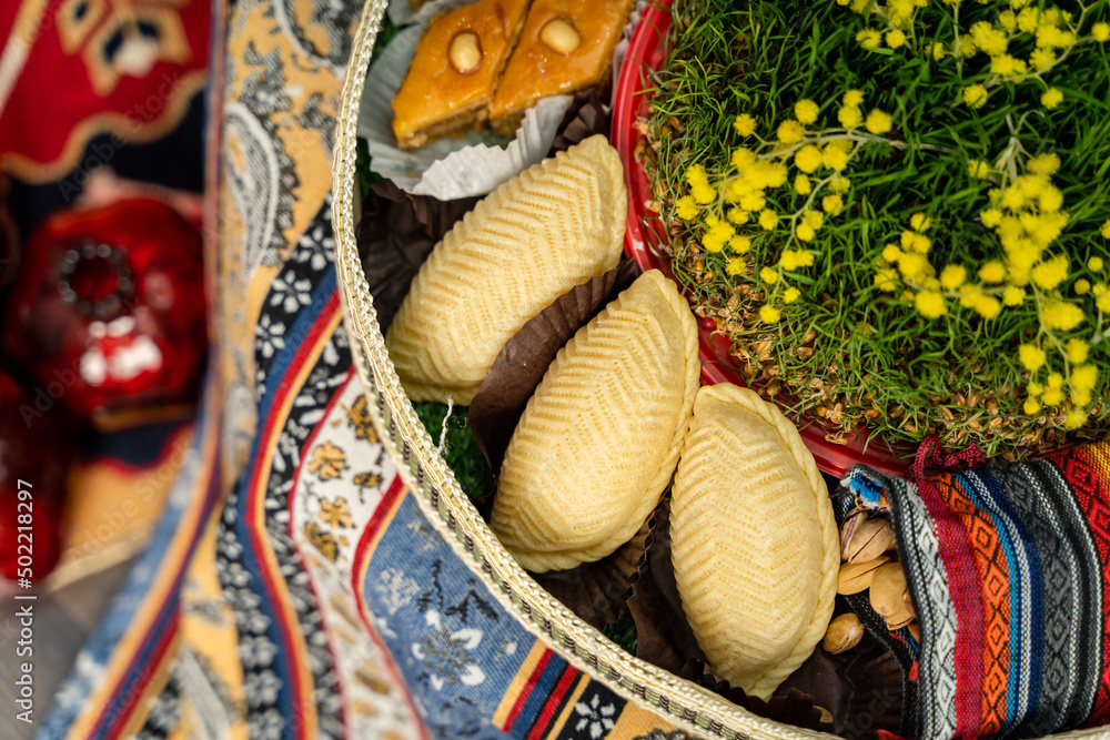Novruz plate with Azerbaijan national pastry shekerbura and green semeni wheat grass 