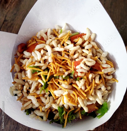 Bhel poori, an Indian road side snack in a conical shape paper container photo