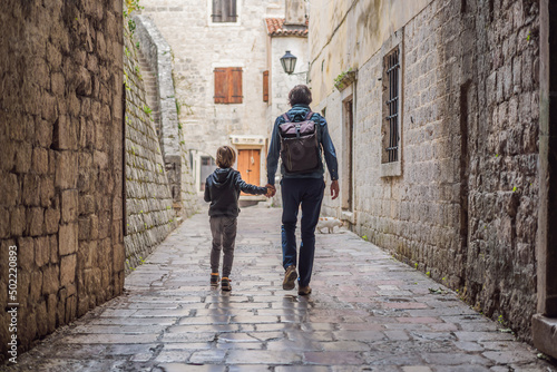 Dad and son travelers enjoying Colorful street in Old town of Kotor on a sunny day, Montenegro. Travel to Montenegro concept