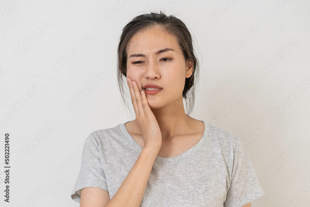 Closing eyes asian young woman touching cheek, face expression from toothache, tooth decay or sensitivity, Having tooth or teeth problem or inflammation, suffering from health. Sensitive teeth people Closing eyes asian young woman touching cheek, face expression from toothache, tooth decay or sensitivity, Having tooth or teeth problem or inflammation, suffering from health. Sensitive teeth people