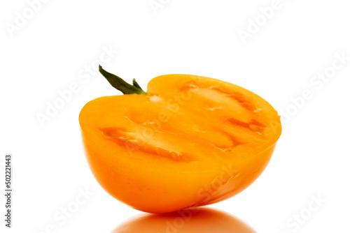 One half of an organic yellow tomato, close-up, isolated on a white background.