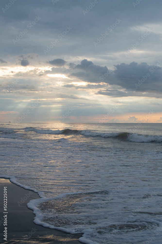 Fototapeta premium Sunlight filters through the clouds over the ocean