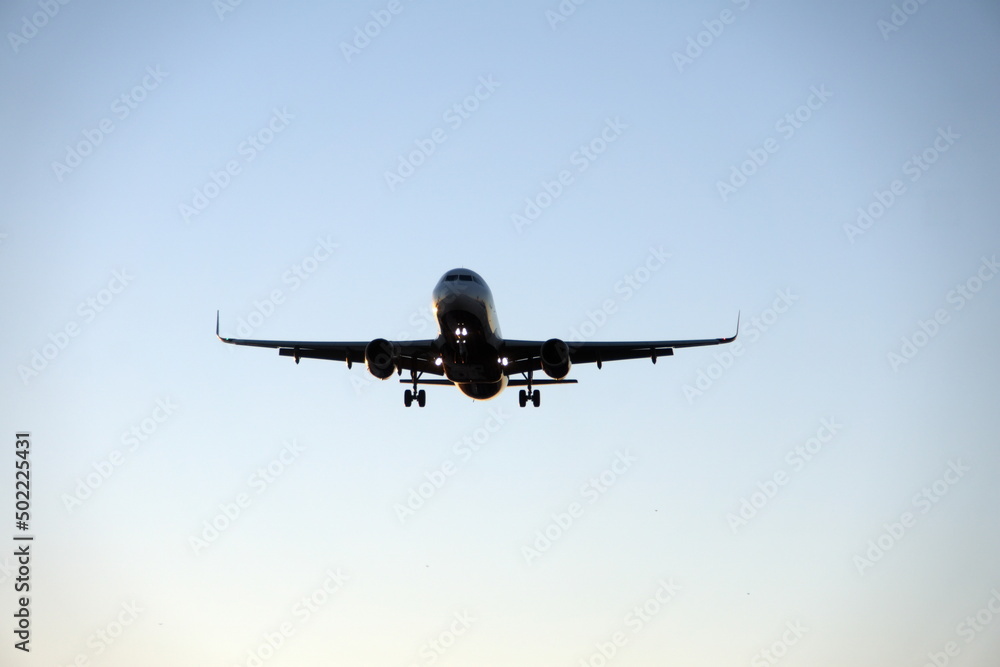 Commercial jet flying, in silhouette, in the evening, in Fort Lauderdale, Florida, USA Commercial jet flying, in silhouette, in the evening, in Fort Lauderdale, Florida, USA
