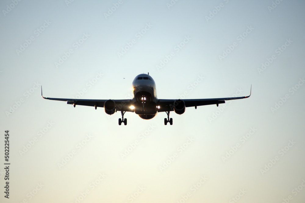 Commercial jet flying, in silhouette, in the evening, in Fort Lauderdale, Florida, USA Commercial jet flying, in silhouette, in the evening, in Fort Lauderdale, Florida, USA