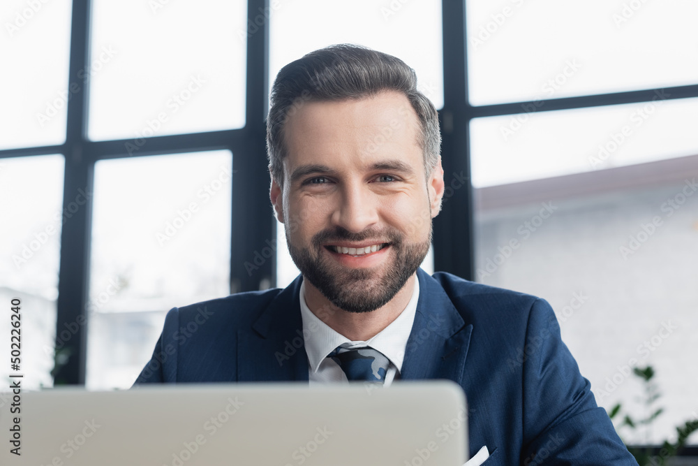 portrait of happy bearded businessman looking at camera on blurred foreground. portrait of happy bearded businessman looking at camera on blurred foreground.