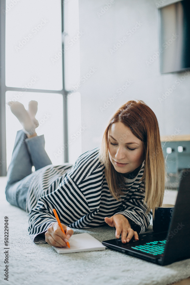Young woman working and studying on her laptop from home Young woman working and studying on her laptop from home