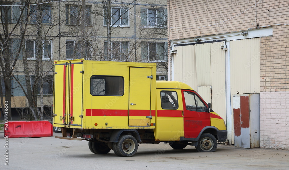 Yellow-red special emergency vehicle with flat front wheel, Podvoysky Street, Saint Petersburg, Russia, May 2022