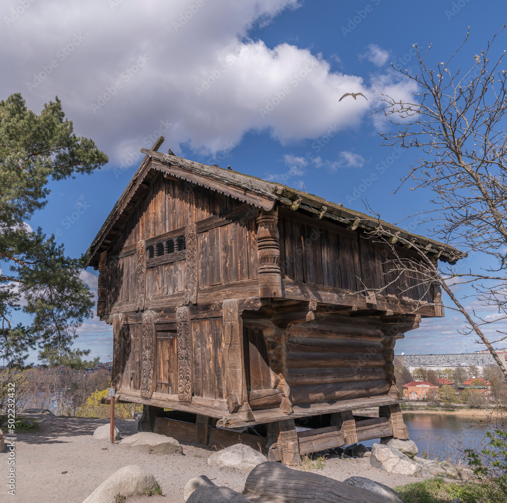 Old 1300s Norwegian log house, storage shed in a park a sunny spring day in Stockholm Old 1300s Norwegian log house, storage shed in a park a sunny spring day in Stockholm