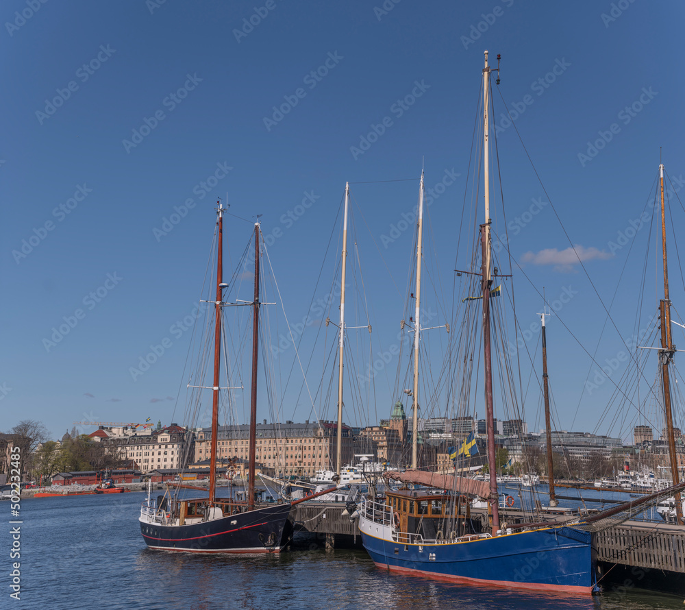 Old sail boats at a pier in the bay Ladugårdsgärdesviken a sunny spring day in Stockholm