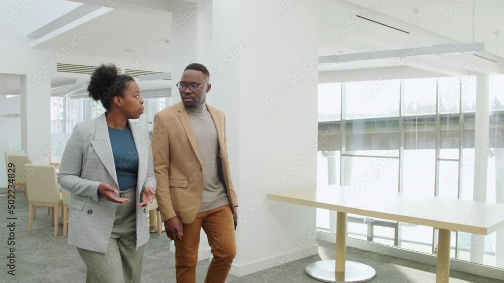 Two talking business people walking in office Two talking business people walking in office