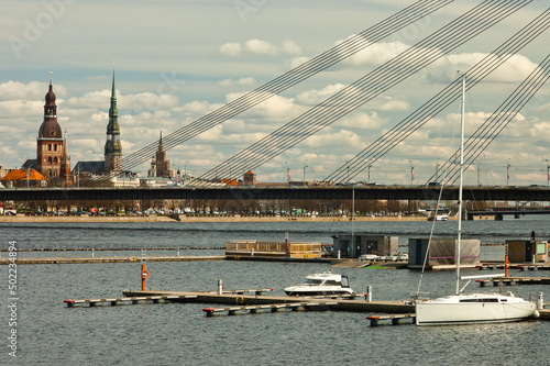 riga city panorama, daugava river in the foreground, blue sky and white clouds in the background