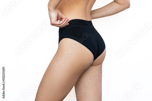 Canvas Print Cropped shot of young slim fit woman in black panties with smooth skin on her thighs isolated on a white background