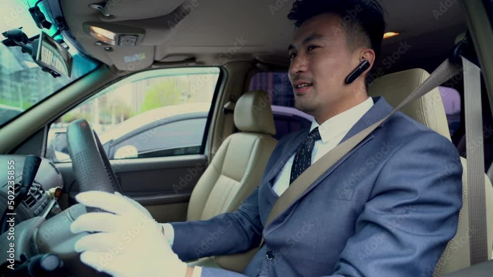 a business man driving a car wearing wireless headphones a business man driving a car wearing wireless headphones