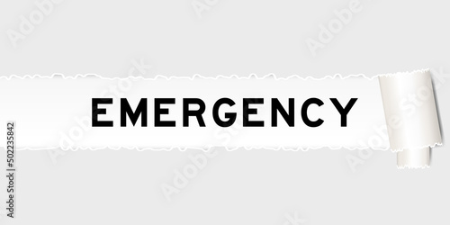 Ripped gray paper background that have word emergency under torn part