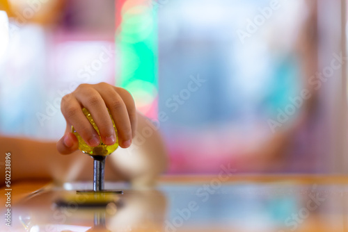 The kid hand is controlling the arcade of the doll