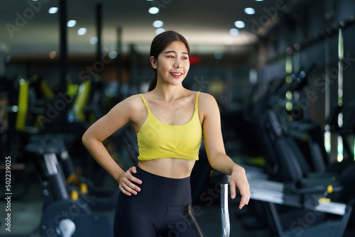 Beautiful Asian woman in sportswear relax tired from exercise at gym.