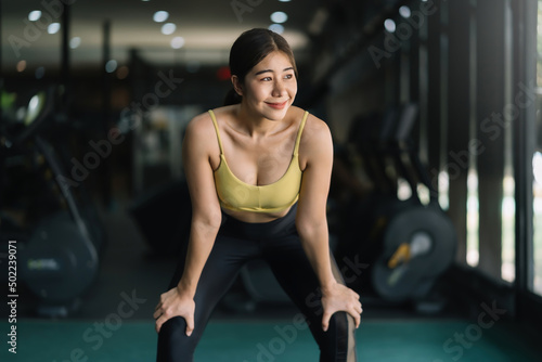 Beautiful Asian woman in sportswear relax tired from exercise at gym.