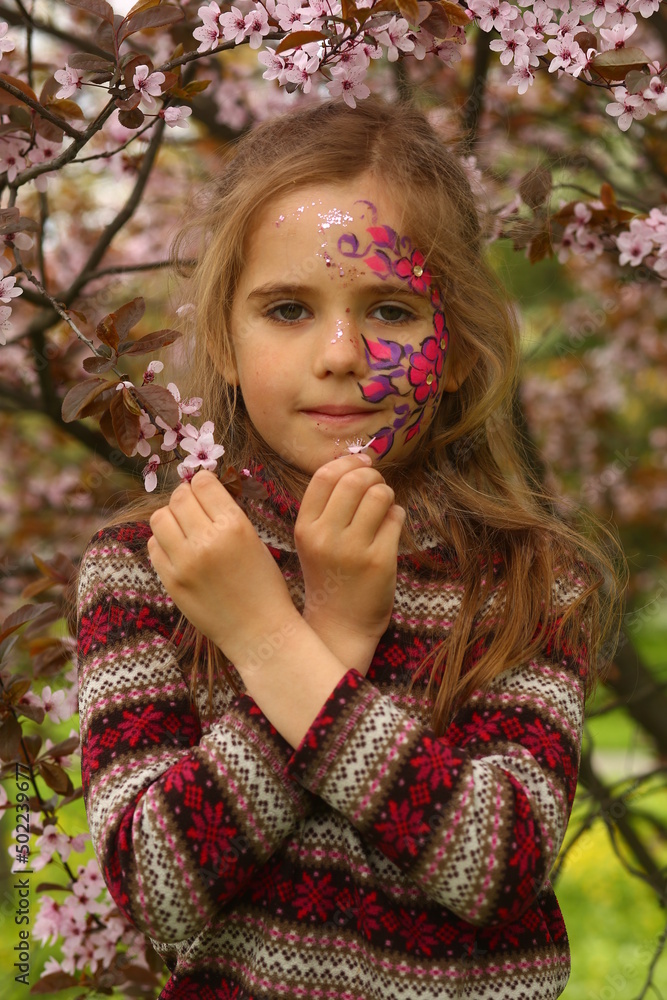 Spring portrait of a six year old girl standing under the blooming pink cherry tree Spring portrait of a six year old girl standing under the blooming pink cherry tree