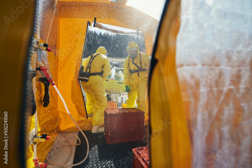 Decontamination of biohazard team of emergency medical service in protective suits.. photo