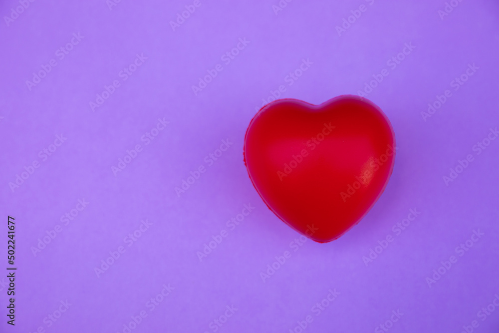Red heart shape on a lilac background.Top view. Copy space.MOCKUP Concept of love and health.