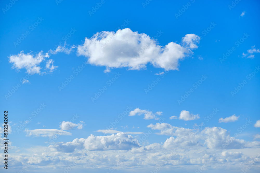 Blue sky with white cumulus clouds. Bright sunny day with cloudy sky