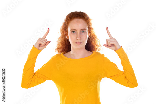 Redhaired girl with yellow t-shirt pointing at something photo