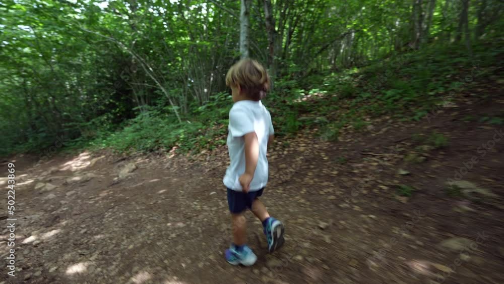 One active little boy trekking outside in nature forest path One active little boy trekking outside in nature forest path