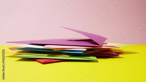 Stop motion animation stack of colored envelopes on a yellow background